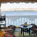 Traditional Bedouin-style floor cushions and a small table on a wooden boat deck.