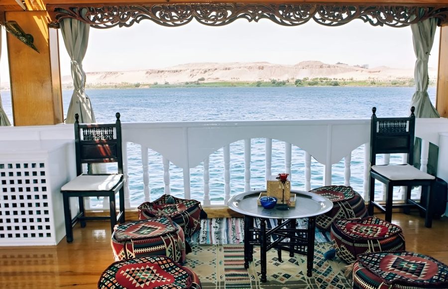 Traditional Bedouin-style floor cushions and a small table on a wooden boat deck.