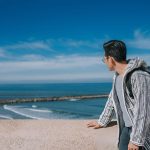 An-Asian-Chinese-male-tourist-looking-at-North-Atlantic-Ocean-Rabat-beach-viewing-from-Kasbah-of-the-Udayas