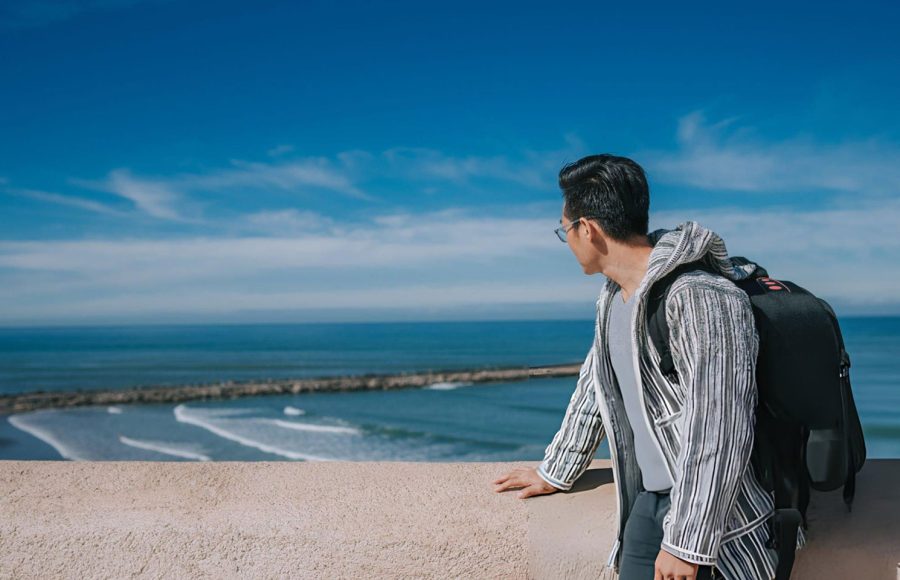 An-Asian-Chinese-male-tourist-looking-at-North-Atlantic-Ocean-Rabat-beach-viewing-from-Kasbah-of-the-Udayas