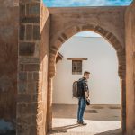 Asian-Chinese-male-tourist-exploring-alley-of-Kasbah-of-the-Udayas-on-sunny-day