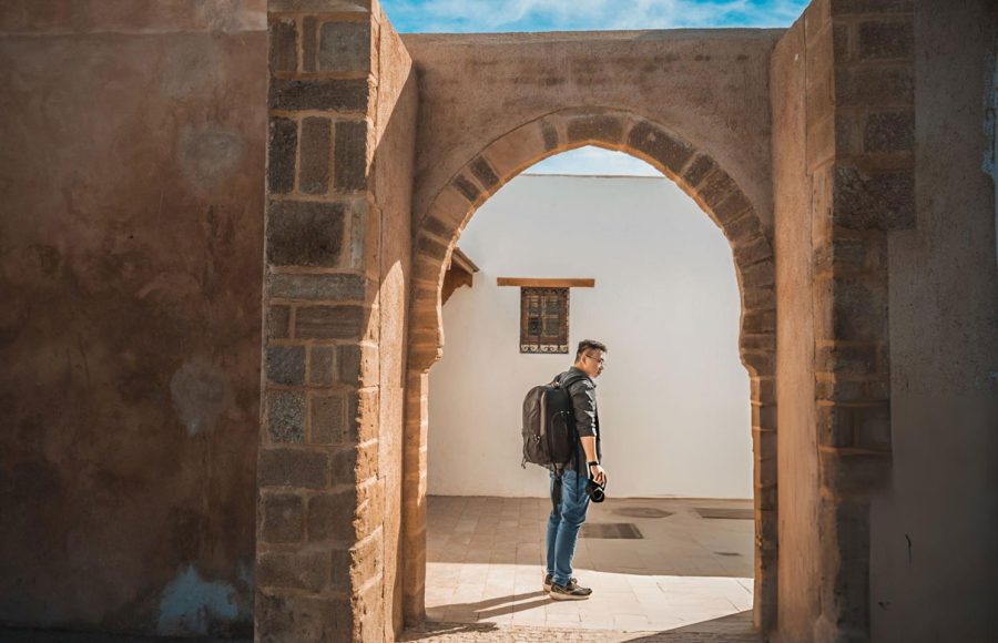 Asian-Chinese-male-tourist-exploring-alley-of-Kasbah-of-the-Udayas-on-sunny-day