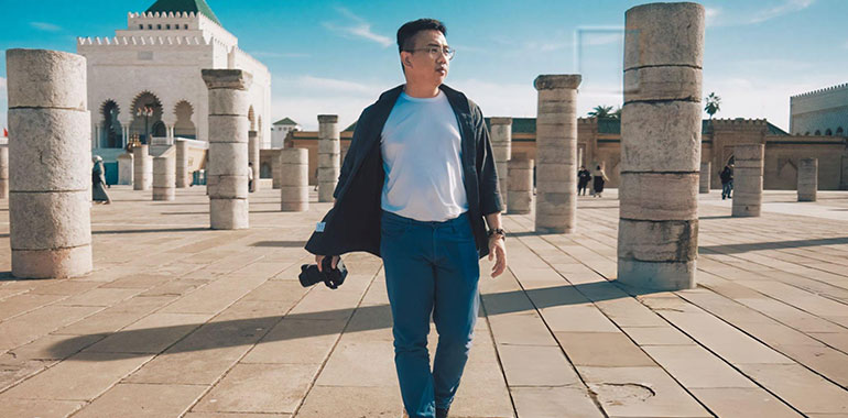Asian Chinese male tourist walking at Hassan Tower Rabat