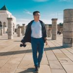 Asian-Chinese-male-tourist-walking-at-Hassan-Tower-in-Rabat-Morocco