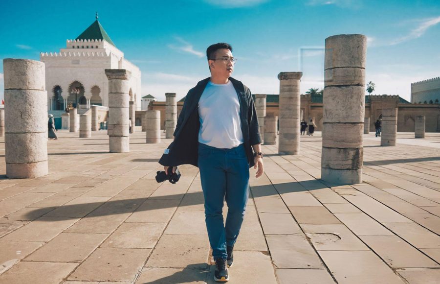 Asian-Chinese-male-tourist-walking-at-Hassan-Tower-in-Rabat-Morocco