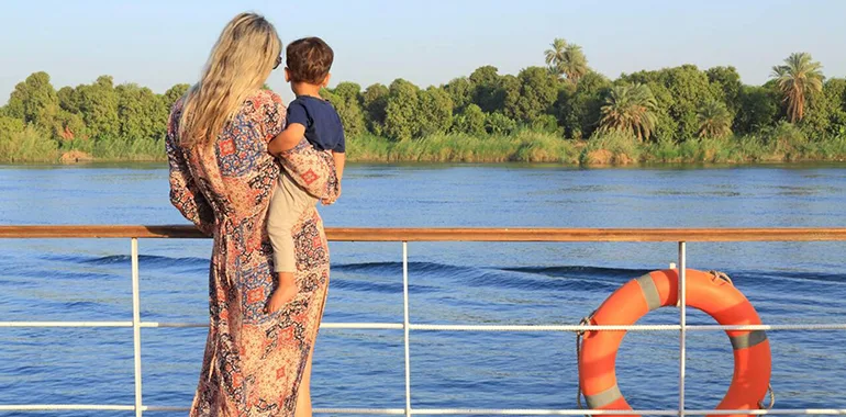 Woman And Child On A Nile Cruise Deck, Overlooking The River.