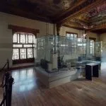 Inside the beautiful museum hall, a highlight of any Cairo highlights tour, showcasing artifacts in glass cases and historic architecture.