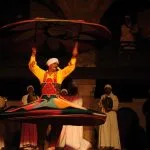 Close up of a skilled performer spinning a colorful weighted skirt during a Cairo cultural dance show