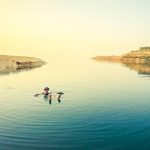 Caucasian-female-tourist-float-on-dead-sea-water-happy-enjoy-vacation-in-Jordan