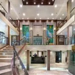 Multi-level cruise ship reception area with staircase and lift.