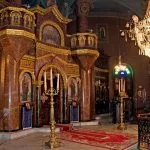Ornate interior sanctuary of a church in Coptic Old Cairo, featuring icons and a large chandelier.