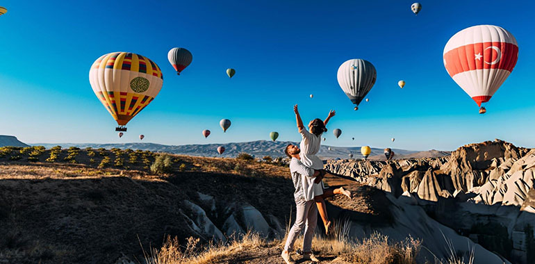 Couple in love among balloons in Cappadocia Turkey