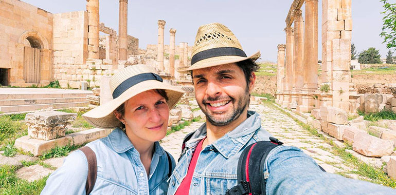 Couple Taking Selfie Photo In Front Of The Roman Ruin Of Jerash