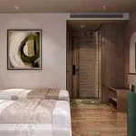 Twin-bed cabin with wood paneling, an abstract painting, and a vanity area.