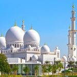 Domes-of-the-Sheikh-Zayed-Grand-Mosque-against-blue-sky-during-sunny-day-in-Abu-Dhabi-in-United-Arab-Emirates