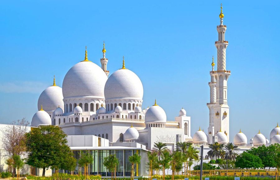 Domes-of-the-Sheikh-Zayed-Grand-Mosque-against-blue-sky-during-sunny-day-in-Abu-Dhabi-in-United-Arab-Emirates