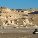 4x4 vehicle driving through the White Desert landscape in Egypt for a desert adventure.