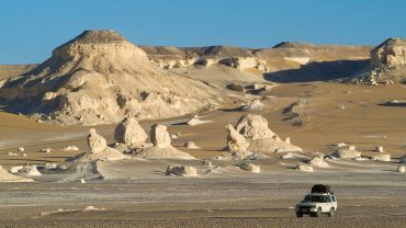 4x4 vehicle driving through the White Desert landscape in Egypt for a desert adventure.