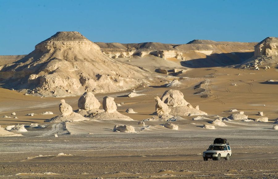 4x4 vehicle driving through the White Desert landscape in Egypt for a desert adventure.