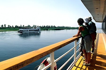 Two Travelers Stand On The Deck Of A Cruise Ship, An Essential Part Of The 10 Day Nile Cruise And Cairo Itinerary.