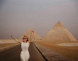 Tourist at Giza Pyramids, a highlight of Egypt Package Tours From Australia. A happy tourist in front of the Giza Pyramids, a key destination for package tours to Egypt from Australia.