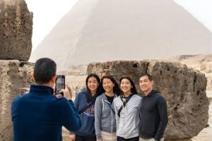 Family taking a photo at the Egyptian pyramids on a private tour from the Philippines.