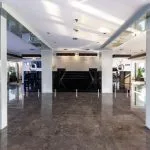 Modern reception and lobby area of the MS Farah cruise ship with glossy black marble flooring, white pillars, and a dark reception desk.