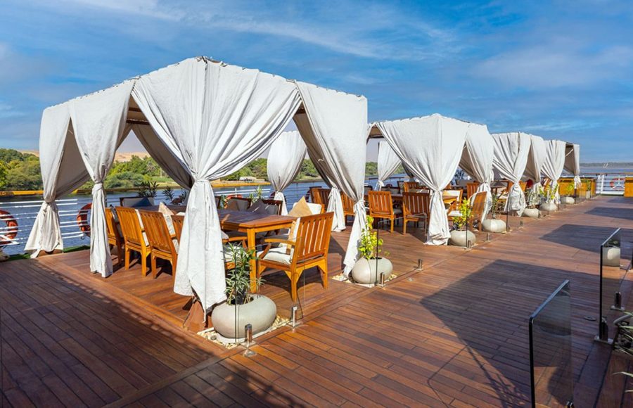 MS Farah Nile cruise ship sailing on the river under a clear blue sky.