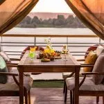 MS Farah Nile cruise ship sailing on the river under a clear blue sky.