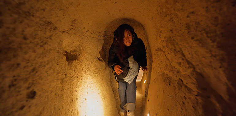 Female solo traveler visiting ancient underground city in Cappadocia