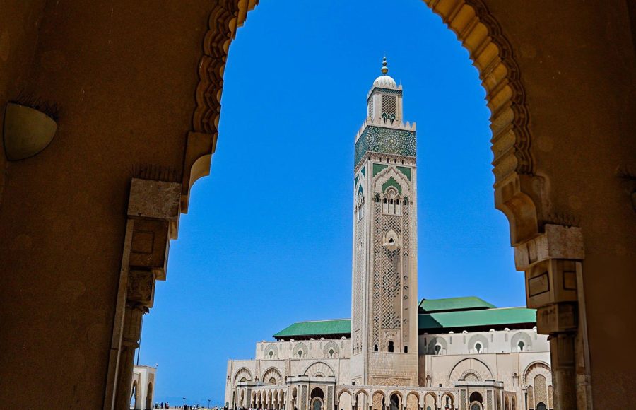 Framed-view-of-the-Hassan-II-Mosque-minaret-through-an-ornate-archway-in-Casablanca-with-clear-sky