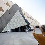 A visitor captures a photo of the stunning triangular architecture during a GEM private tour