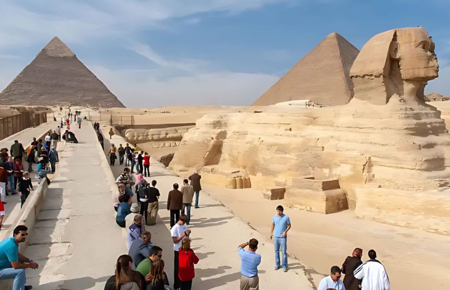 Wide view of travelers exploring the Great Sphinx and ancient plateaus on a GEM and pyramids day trip