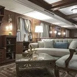 Wood-paneled living room with a grey sofa and television.