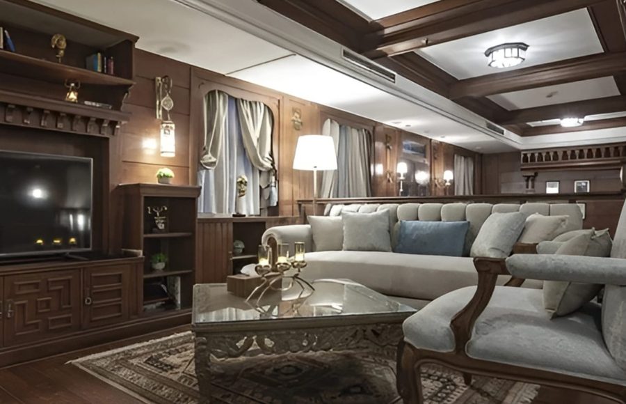 Wood-paneled living room with a grey sofa and television.