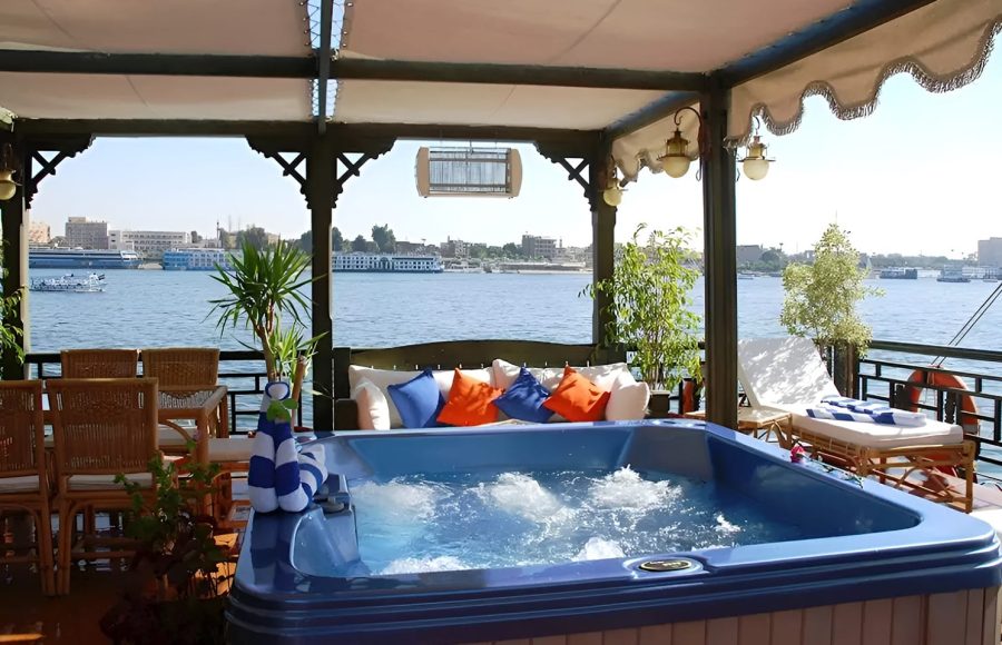 Blue outdoor hot tub on a boat deck overlooking the river.