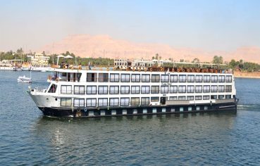 A large, white and black multi-deck Nile cruise ship named 