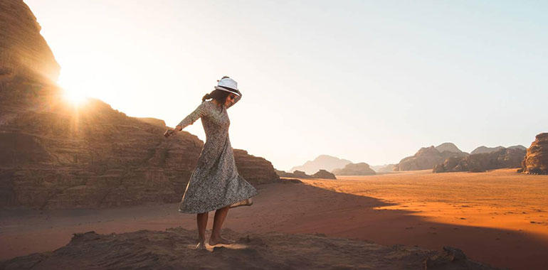Happy Joyful Woman Tourist Stand And Dance On Cliff Barefoot At Viewpoint And Enjoy Holiday Vacation In Wadi Rum Panorama On Sunrise