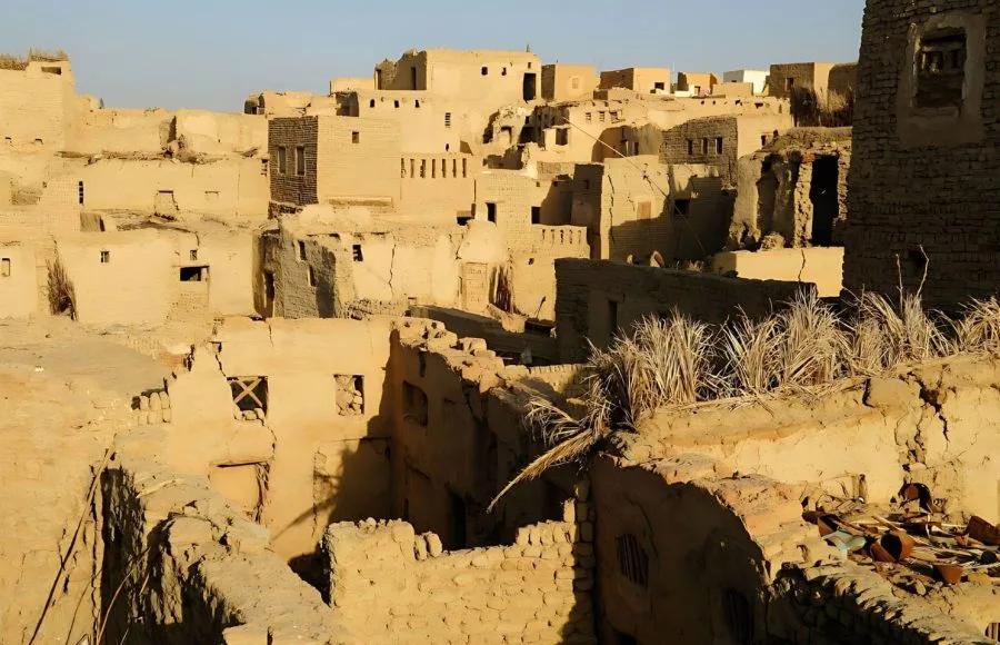 The densely packed, ancient mud-brick architecture at the Heart Of The Old Covered City Of Al Qasr In Dakhla Oasis, showing crumbling buildings and narrow pathways.