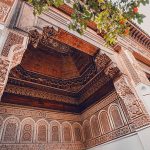 Intricate-carvings-and-geometric-patterns-adorn-the-walls-and-ceiling-of-Bahia-Palace-showcasing-traditional-Moroccan-artistry
