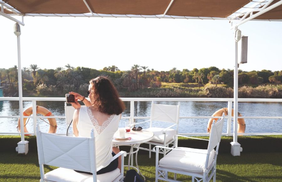 Woman taking a photo from the sun deck of the Jaz Imperial Nile Cruise.