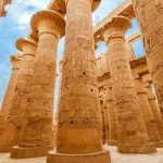 Close-up view of the giant, carved columns in the Hypostyle Hall of Karnak Temple, Luxor, Egypt.