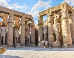 The impressive colonnade and statues of Luxor Temple under a bright sky, a major attraction on a Kolkata to Egypt tour.