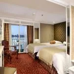 The elegant twin-bed cabin on the La Traviata Nile Cruise featuring a private balcony view.