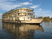 A beautiful exterior view of the multi-deck La Traviata Nile Cruise sailing on the river.