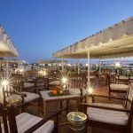 Relaxing seating area on the illuminated sun deck of the La Traviata Nile Cruise at dusk.