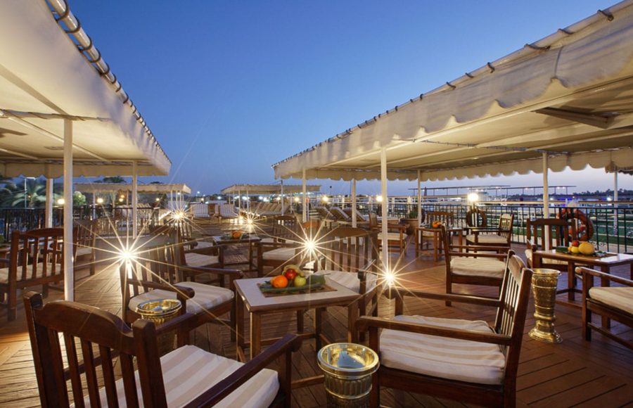 Relaxing seating area on the illuminated sun deck of the La Traviata Nile Cruise at dusk.