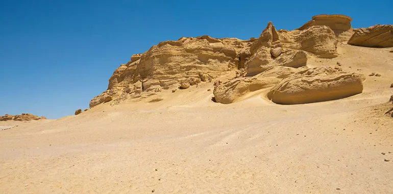 Landscape View Of A Desolate, Barren Western Desert In Egypt With Low, Eroded Yellow Sandstone Cliffs.