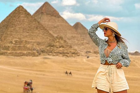A Woman Wearing A Sun Hat Posing In Front Of The Giza Pyramids During A Last-Minute Egypt Tour 9 Days