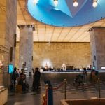 Visitors enjoying a layover excursion in Cairo while exploring the main hall of the National Museum of Egyptian Civilization